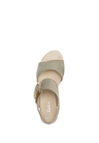 Suede sandal in muted green with a wide strap, circular buckle detail, and a soft beige insole. Flat sole, open-toe design.