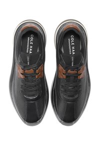 Schwarze Lederschuhe mit einer durchbrochenen Gestaltung, braunen Hardwareakzenten, runder Zehenpartie und schwarzen Schnürsenkeln; ausgestattet mit einer gepolsterten Einlegesohle.