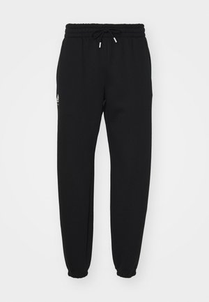 Sorte sweatpants lavet af blødt stof, med en elastisk talje med snøre, elastiske skaft og en lille logo-detalje på siden.