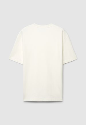 Maglietta in cotone color crema con vestibilità ampia, maniche corte e scollo rotondo. Tessuto liscio senza motivi o dettagli visibili.