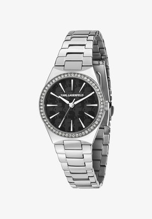 Zilverkleurig metalen horloge met een zwarte wijzerplaat met een camouflagepatroon, kristalaccenten rond de lunette en een schakelbandontwerp.