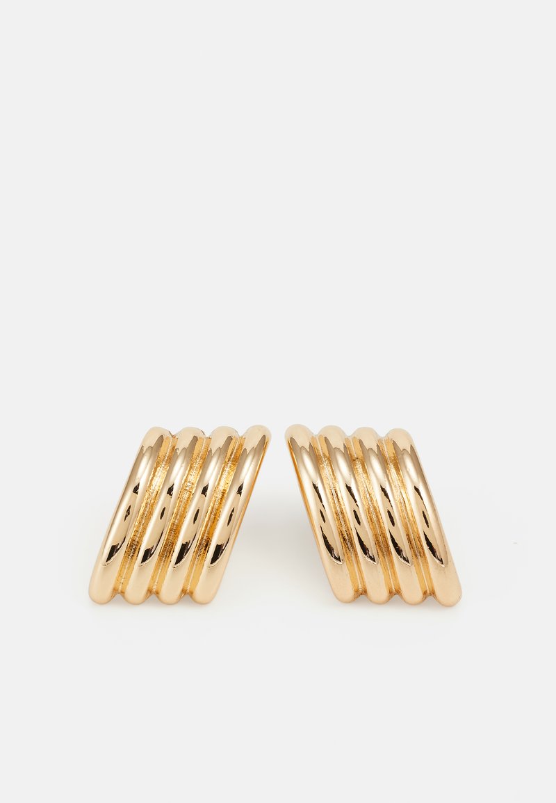 Guldmetallörhängen med en vågig design och sex staplade ringar som reflekterar ljuset med en slät, polerad yta.