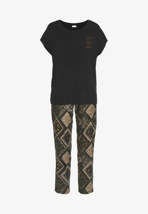 Crna majica kratkih rukava s zlatnim natpisom sprijeda, uparena s hlačama s uzorkom dijamantskih oblika u zemljanim tonovima zelene, bež i smeđe.