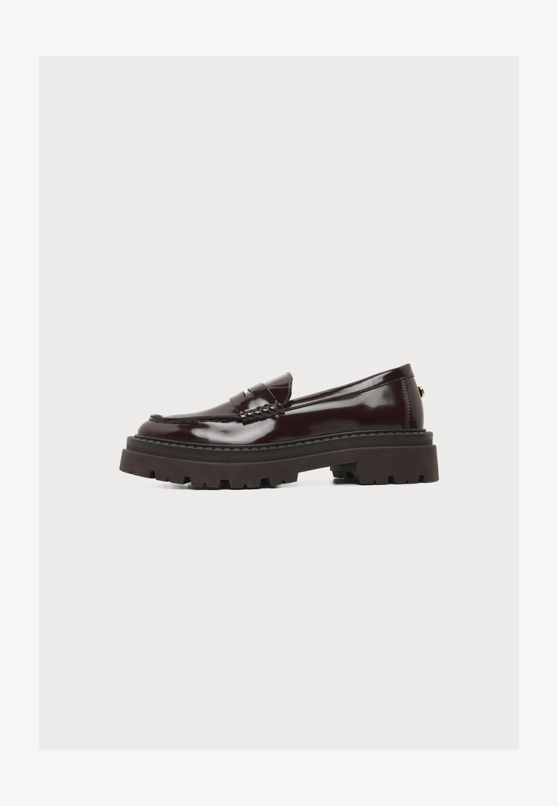 Mocassin en cuir marron foncé brillant avec semelle épaisse à crampons et petit talon, vue de côté sur fond blanc.