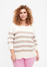 Beige- und weißgestreifter Pullover mit rundem Ausschnitt und Dreiviertelärmeln, aus einem weichen Material. Tragen Sie ihn mit rosa Hosen.