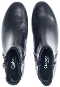 Schwarze Ankle Boots mit glatter Lederoberfläche, runder Zehenpartie, seitlichen Reißverschlüssen für einfachen Zugang und einem weichen Innenfutter.