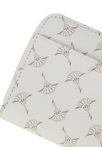 Portafoglio in pelle bianca con un motivo floreale elegante ripetuto in tonalità marrone chiaro, con cuciture visibili lungo i bordi e una finitura testurizzata.
