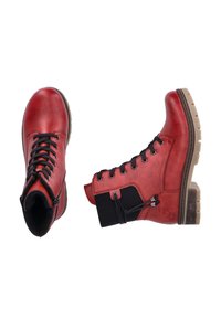 Red leather ankle boots with black laces, a textured panel, and a brown rubber sole. Features a side zipper and decorative stitching.