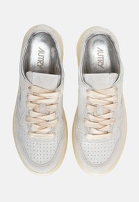 Sneaker bianche in pelle con accenti in suede grigio chiaro, tomaia perforata, lacci beige e loghi argentati sulla linguetta e sulla soletta.