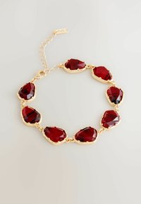 Złota bransoletka z ośmioma nieregularnymi, głęboko czerwonymi, fasetowanymi kamieniami, z zapięciem i regulowanymi ogniwami na jasnym tle.