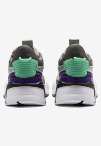 Scarpe sportive caratterizzate da una tomaia grigia, accenti verdi e neri, e una suola bianca imbottita. Dettaglio del tallone rigato notevole e color blocking.