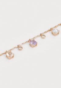 Bracciale a catena color oro con cinque gemme assortite: perle chiare, lavanda e bianche, montate in cornici di metallo a gambo. Maglie texturizzate.