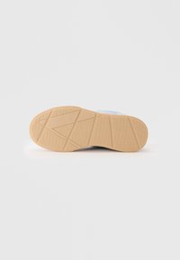 Sneakersåle med teksturert mønster, i en lys beige farge og laget av gummigummi for bedre grep og holdbarhet.