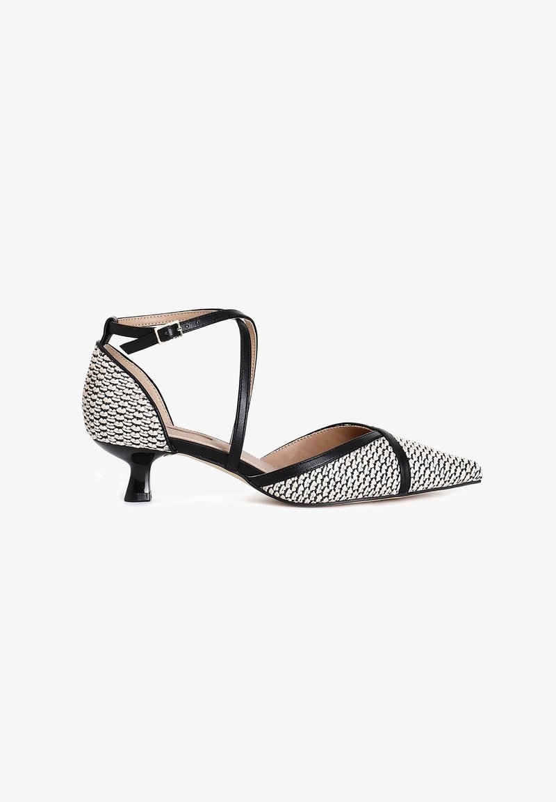 Chaussure à talon kitten tissé noir et blanc à bout pointu, avec bride de cheville et boucle sur fond blanc.