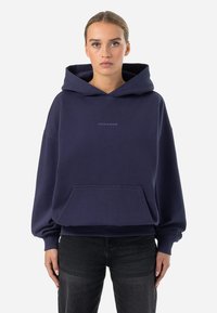 Navyblauer Hoodie mit einer Fronttasche, gerippten Bündchen und Saum. Mit einem dezenten Logo auf der Brust. Aus weichem, dickem Stoff gefertigt.