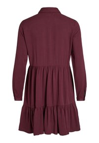 Bordeauxfärgad klänning med långa ärmar, krage, figurnära midja och en utsvängd kjol med en lagd nederkant. Mjuk textur, enkel design.