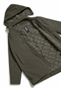 Giacca imbottita verde oliva con cappuccio removibile, zip frontale e chiusure a scatto; presenta tasche laterali e una fodera interna a motivo diamante.