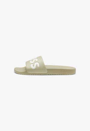 Beige Slide-Sandale mit breitem Riemen, auf dem erhöhte weiße „BOSS“-Buchstaben und eine strukturierte Sohle zu sehen sind.