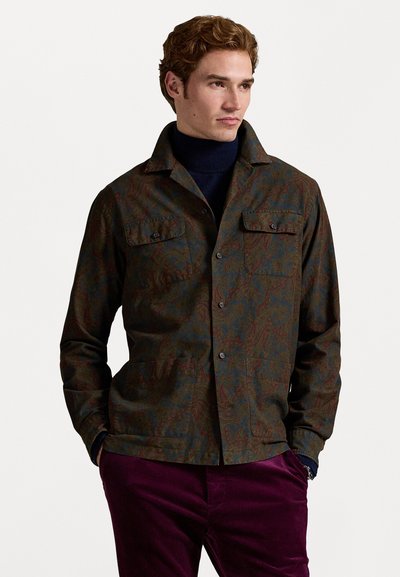 Bruine blouse met patroon, voorzien van twee borstzakken en een kraag, gecombineerd met donkerpaarse corduroy broek. Gestructureerde stof.