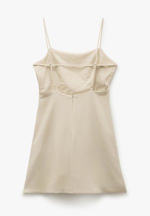 Beige jurk met dunne bandjes, getailleerde lijfje en een uitlopende A-lijn rok. Voorzien van een ritssluiting aan de achterkant en een gladde, zachte textuur.