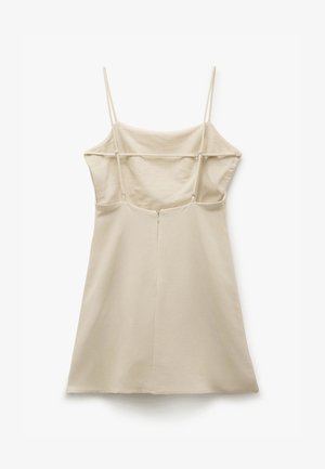 Beige jurk met dunne bandjes, getailleerde lijfje en een uitlopende A-lijn rok. Voorzien van een ritssluiting aan de achterkant en een gladde, zachte textuur.