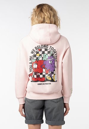 Roze hoodie met een graphic van een rode fruitfiguur en een paarse fruitfiguur op een dambord achtergrond. Inclusief de tekst "Wees altijd positief".