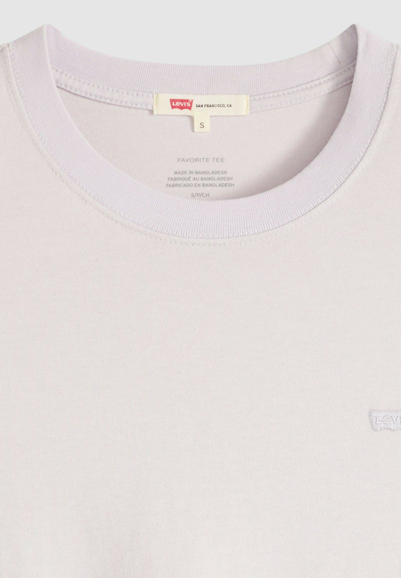 T-shirt Levi's rose clair avec col rond, étiquette taille small et petit logo blanc Levi's sur la poitrine.