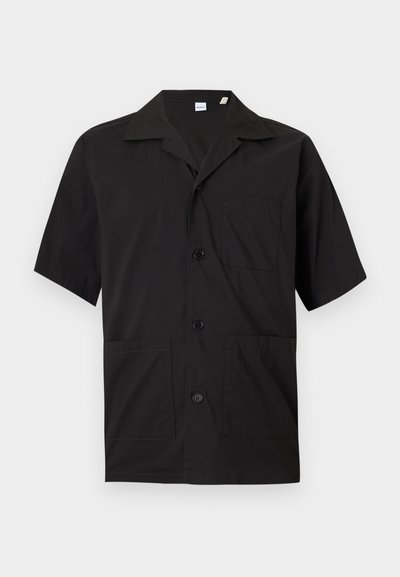 Μαύρο κοντομάνικο πουκάμισο με κουμπιά, γιακά τύπου camp και τρεις μπροστινές τσέπες, εμφανιζόμενο σε απλό φωτεινό φόντο.