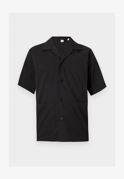 Μαύρο κοντομάνικο πουκάμισο με κουμπιά, γιακά τύπου camp και τρεις μπροστινές τσέπες, εμφανιζόμενο σε απλό φωτεινό φόντο.