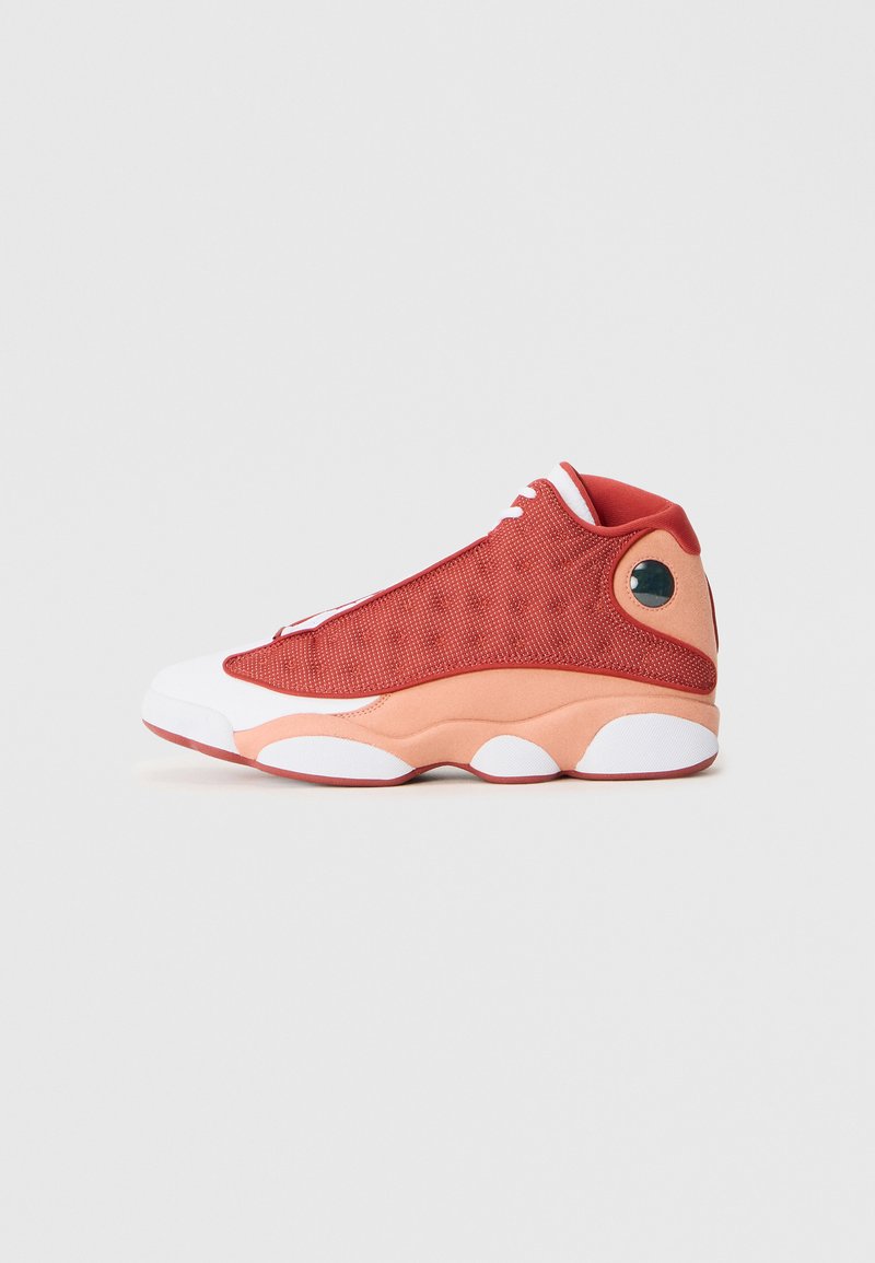 Scarpa da basket in rete rossa con accenti bianchi e pesco, caratterizzata da una punta arrotondata, colletto imbottito e un particolare dettaglio circolare sul tallone.