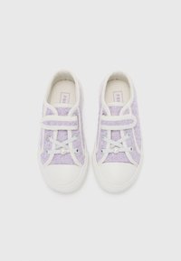Sneakers textile movi de culoare purpurie cu o vârf de cauciuc alb, șireturi albe cu detalii de perle și o curea cu velcro pentru o fixare ușoară.