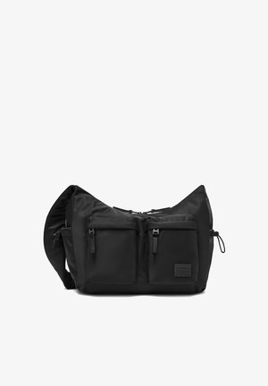 Borsa a tracolla nera con due tasche frontali con cerniera e tracolla regolabile, realizzata in tessuto liscio con una piccola etichetta del marchio sulla parte frontale.