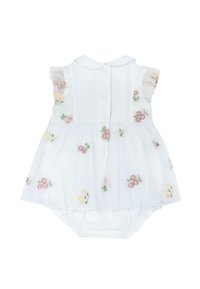 Un barboteuse blanche pour bébé avec des manches volantes transparentes et un superposé de jupe brodé de motifs floraux roses et jaunes, et des fermetures à boutons à l'arrière.