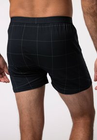 Boxer in cotone nero realizzati in morbido tessuto, caratterizzati da un motivo a griglia grigia, con cintura elastica e marchio JP1880, e design aderente.