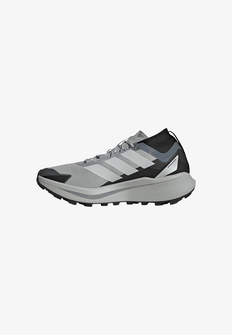 Chaussure de sport grise avec tige en mesh, accents noirs, trois bandes blanches sur le côté et une semelle épaisse pour l'amorti.