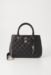 Sac à main matelassé noir Guess avec double poignées, bandoulière chaîne dorée, et pendentif logo sur fond blanc uni.