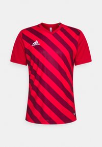 Rød atletisk trøje med diagonale mørkerøde striber, korte ærmer, V-hals og et hvidt Adidas-logo på venstre bryst.