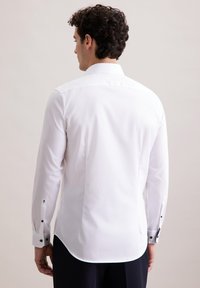 Witte blouse met lange mouwen, een rechte zoom, een verspreide kraag en zwarte knoopmanchetten. Kenmerkt zich door een gladde textuur en een slim fit ontwerp.