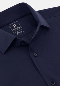 Tmavomodrá košeľa na gombíky so stojacím golierom a légou, vo vnútri goliera s označením značky "Boggi Milano Jersey".