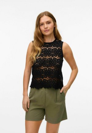 Haut sans manches en dentelle noire avec un motif floral et un ourlet en feston, porté avec un short vert olive, mettant en valeur une texture détaillée et des sections transparentes.
