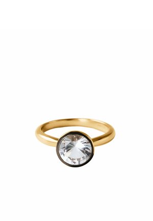 Anillo de oro con una piedra preciosa facetada redonda y clara, montada en un engaste biselado sobre un fondo blanco.