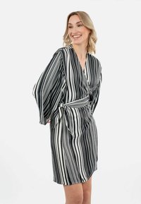 Vestido envolvente a rayas en blanco y negro con mangas anchas, atado en la cintura, que presenta una textura suave y lisa y un corte hasta la rodilla.