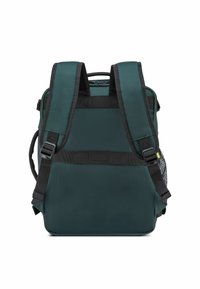 Zaino verde scuro con spalline nere, tessuto testurizzato e tasca laterale in rete. Presenta spalline regolabili e una maniglia di trasporto rinforzata.