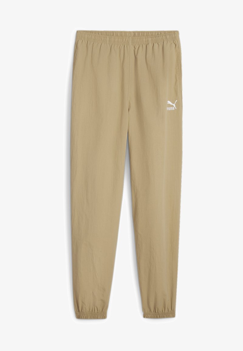 Beige Jogginghose mit einem elastischen Bund, gerippten Knöcheln und einem weißen Puma-Logo am linken Bein. Leichter, glatter Stoff.