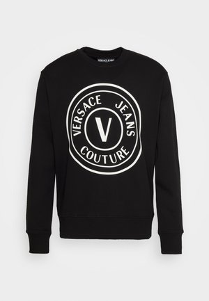 Felpa nera con maniche lunghe, scollatura rotonda e grande logo bianco con il testo "VERSACE JEANS COUTURE" e una "V" centrale.