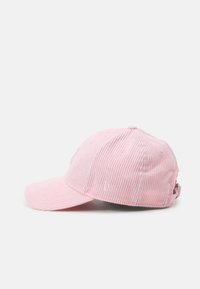 Boné de basquete em corduroy rosa com aba curve, superfície texturizada e cinta ajustável na parte de trás. Detalhe de logotipo bordado na frente.