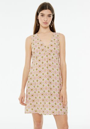 Vestido sin mangas con escote en V, que presenta un patrón geométrico en tonos rosa y beige, hecho de una tela ligera.