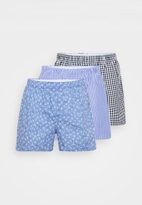 Tre par med boksershorts: en med blå blomsterprint, en med blå striper og en i svart-hvit rutete. Myk stoff, elastiske linninger.