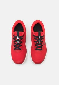 Czerwone, plecione siatkowe buty sportowe z czarnymi sznurowadłami i wyściełanym językiem. Posiadają białą podeszwę i szczegółowe logo z boku.