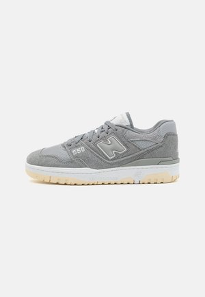 Grauer New Balance 550 Sneaker mit Wildleder- und Mesh-Obermaterial, weißer Zwischensohle, Gummiaußensohle und "N"-Logo an der Seite.